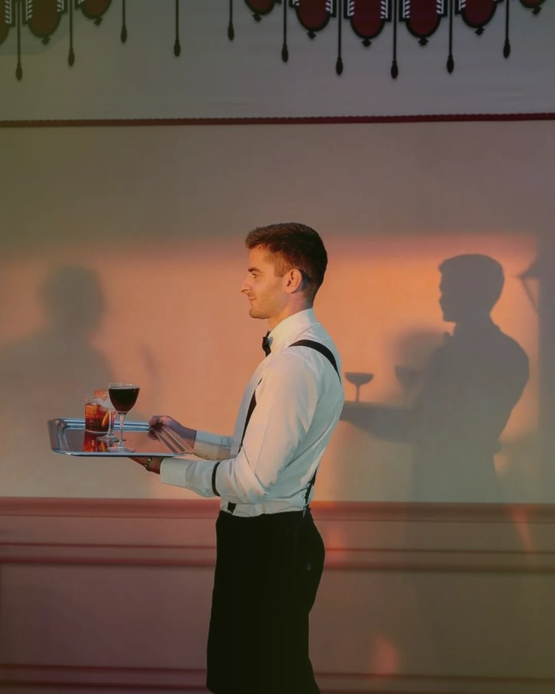 Serveur portant un plateau de cocktails lors d’une réception professionnelle
